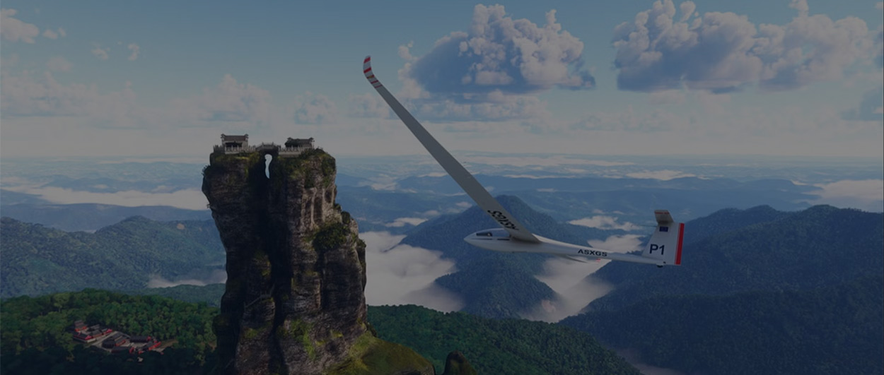 A glider flying through the sky as forests and mountains stretch below and in to the horizon.